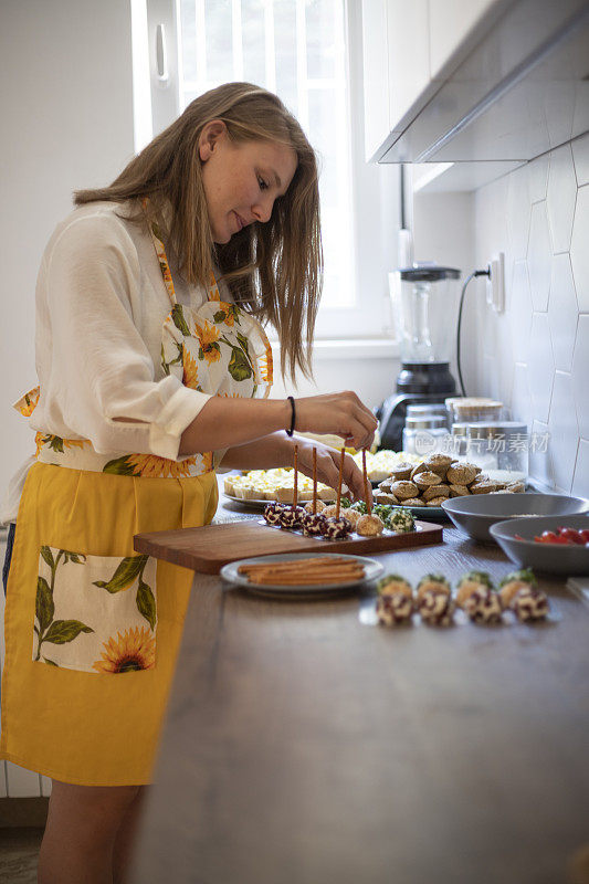 Young girl is making canapes